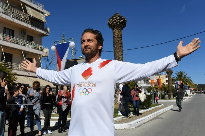 US actor Gerard Butler takes part in the Olympic flame torch relay for the Tokyo 2020 Summer Olympics