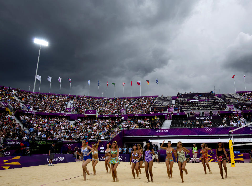 Rain clouds gather as dancers entertain spectators at the Horse Guards Parade before a Beach Volleyball match in London