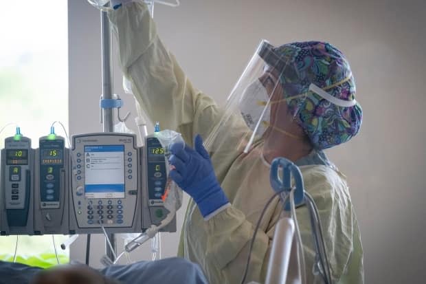 A nurse tends to a patient suspected of having COVID-19 in an intensive care unit in this file photo. A total of 174 children (19 years and under) have been admitted to Alberta hospitals over the course of the pandemic. (Evan Mitsui/CBC - image credit)