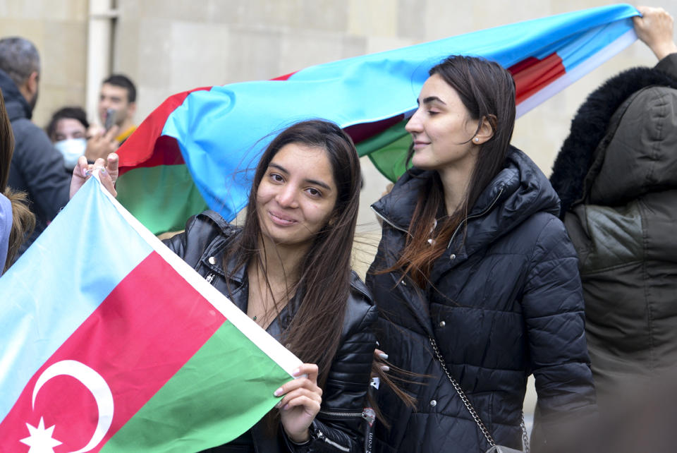 Azerbaijanis with the national flags celebrate after the country's President claimed Azerbaijani forces have taken Shushi, a key city in the Nagorno-Karabakh region that has been under the control of ethnic Armenians for decades in Baku, Azerbaijan, Sunday, Nov. 8, 2020. (AP Photo)
