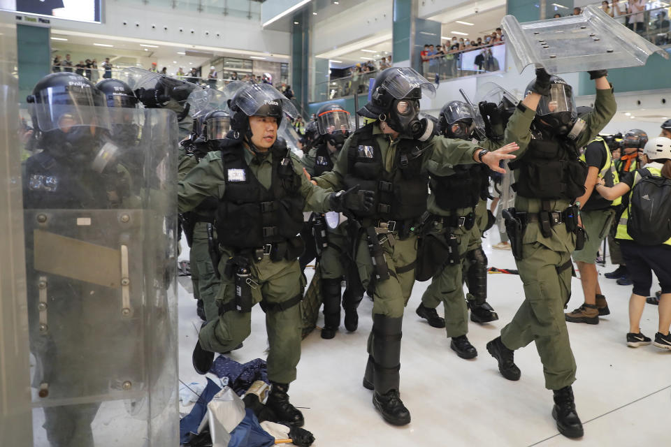 Riot policemen move in to clear the protesters inside a mall in Sha Tin District in Hong Kong, Sunday, July 14, 2019. Police in Hong Kong have fought with protesters as they broke up a demonstration by thousands of people demanding the resignation of the Chinese territory's chief executive and an investigation into complains of police violence. (AP Photo/Kin Cheung)