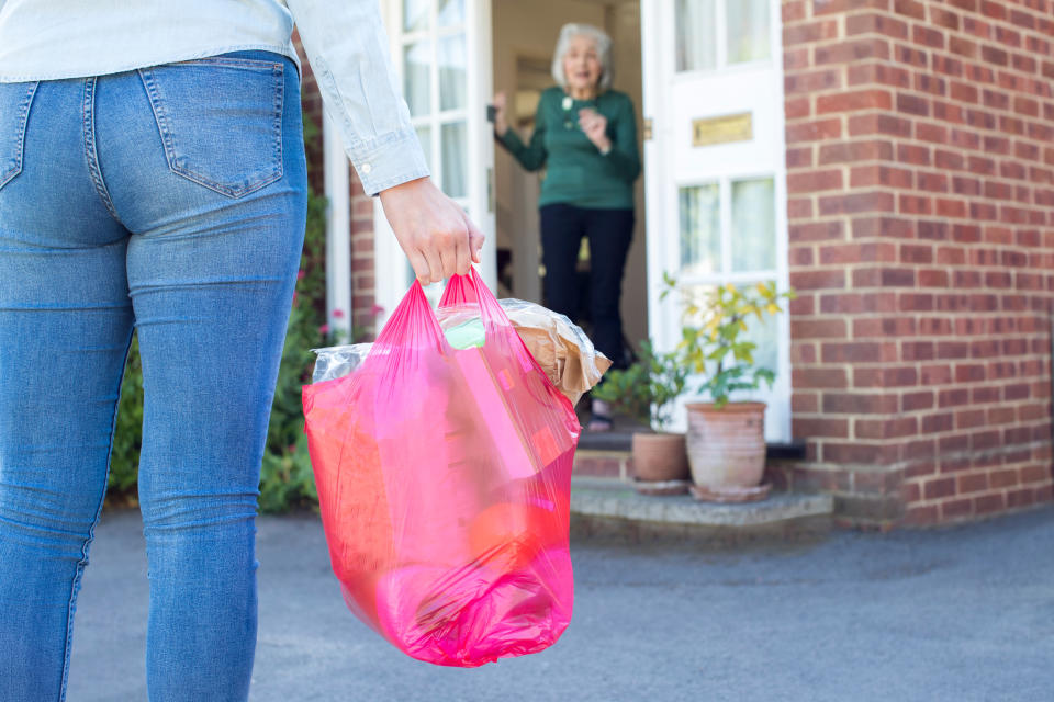 Close Up Of Woman Doing Shopping For Senior Neighbor