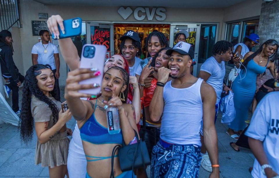 A group of spring breakers take selfies as they dance around in the sidewalk on Ocean Drives, during spring break in Miami Beach, on Saturday March 16, 2024.