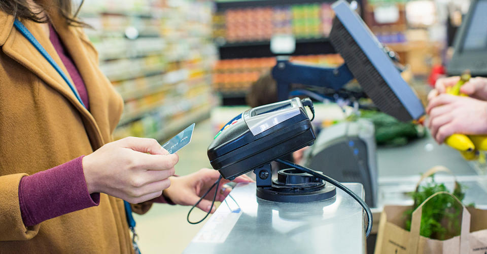 Woman putting her card into the machine at a checkout