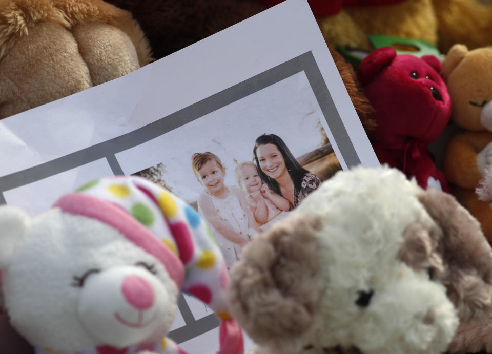 FILE - In this Thursday, Aug. 16, 2018 file photo, a photograph sits amid mementos outside the home where a pregnant woman, Shanann Watts, and her two daughters, Bella and Celeste, lived in Frederick, Colo. Colorado prosecutors want a judge to block release of the autopsy reports of a woman and two young girls found dead at an oil work site, arguing that the cause of their deaths will be "critical evidence" during the trial of the man accused of killing his family. In a request filed in Weld County Court on Monday, Sept. 17, 2018, District Attorney Michael Rourke said releasing information from the autopsies could influence witnesses and affect future jurors. Watts, 33, was arrested and charged in August with murdering his 34-year-old pregnant wife, Shanann, and their two daughters, four-year-old Bella and three-year-old Celeste. (AP Photo/David Zalubowski, File)