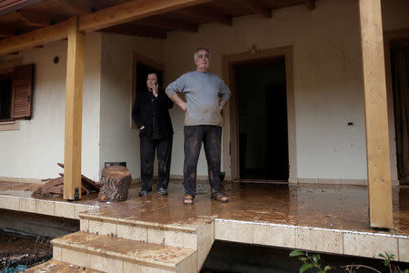 Locals stand at the entrance of their destroyed house following a heavy rainfall in the town of Mandra, Greece, November 15, 2017. REUTERS/Alkis Konstantinidis