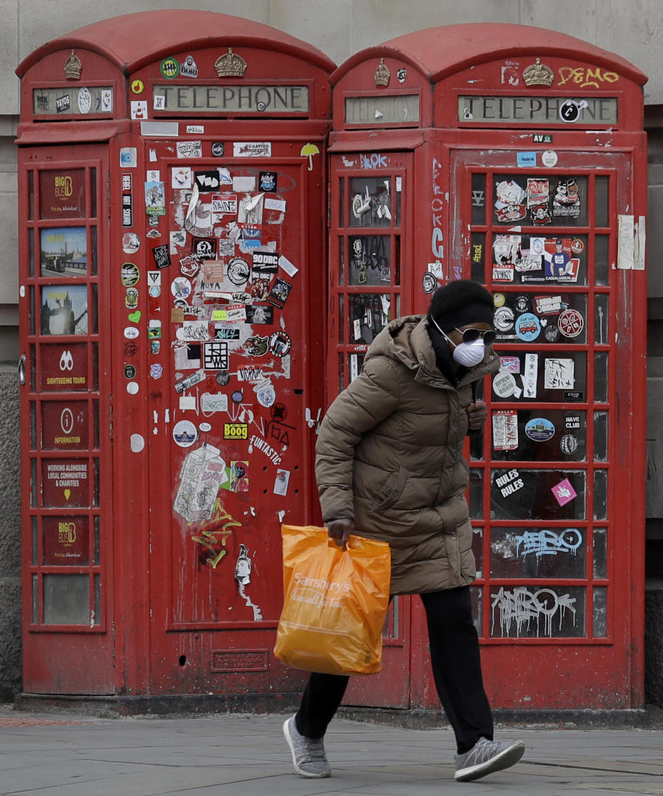 FILE - In this Saturday, April 18, 2020 file photo a woman wears a protective mask to protect from coronavirus, in Westminster as the country continues its lockdown in an attempt to control the spread of the coronavirus, in London. (AP Photo/Kirsty Wigglesworth, File)