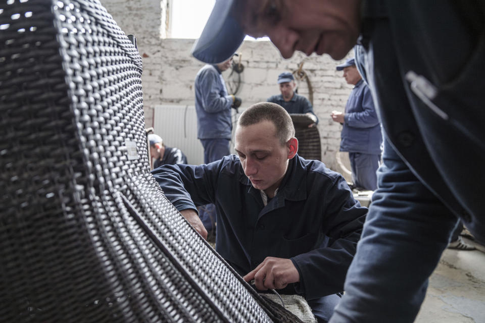 Russian prisoner of war Alexander, 24, makes garden furniture at a detention center in Ukraine's Lviv region, Thursday, April 25, 2024. AP visited the center as part of a small group of journalists on the condition that its exact location be withheld and spoke with Russian POWs, who gave only their first names. (AP Photo/Evgeniy Maloletka)