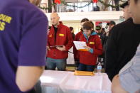 The judges make notes as participants explain their creations.