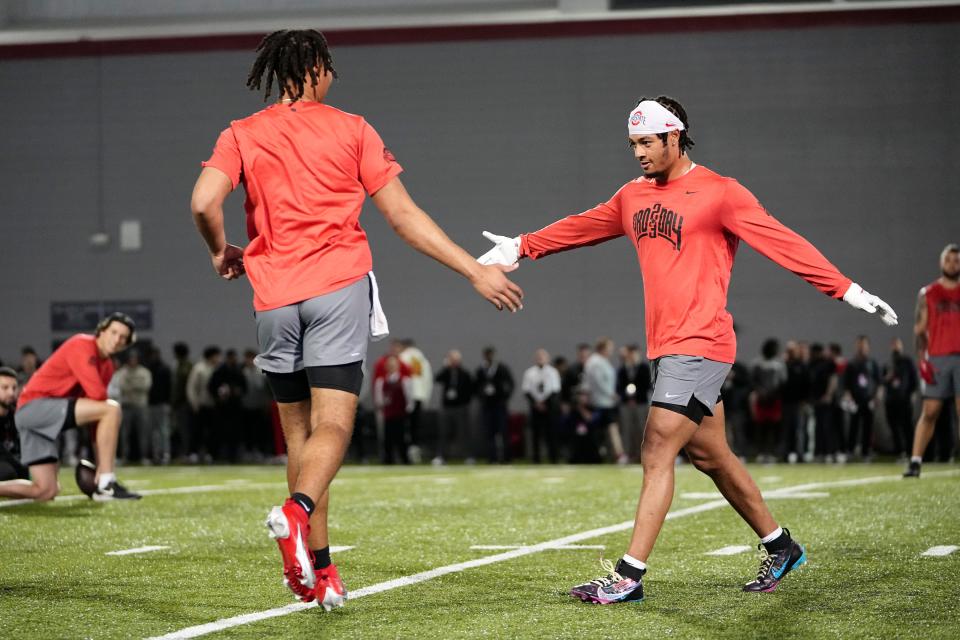 Ohio State Buckeyes quarterback C.J. Stroud  high fives wide receiver Jaxon Smith-Njigba during Ohio State football’s pro day at the Woody Hayes Athletic Center in Columbus on March 22, 2023. 