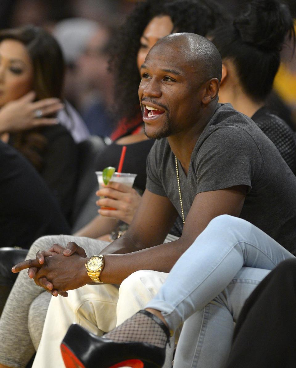 Boxer Floyd Mayweather watches the Los Angeles Lakers play the Boston Celtics during the second half of an NBA basketball game, Friday, Feb. 21, 2014, in Los Angeles. (AP Photo/Mark J. Terrill)