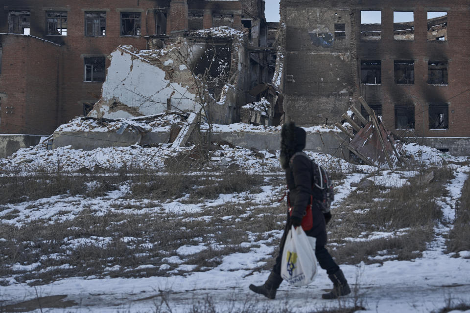 A local resident walks along a street in Bakhmut, Donetsk region, Ukraine, Friday, Feb. 10, 2023. (AP Photo/Libkos)