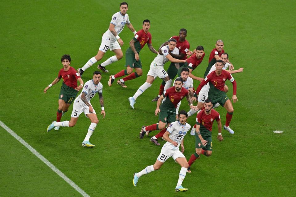 Uruguay’s forward #21 Edinson Cavani (bottom) eyes the ball during the Qatar 2022 World Cup Group H match between Portugal and Uruguay at the Lusail Stadium in Lusail, north of Doh (AFP via Getty Images)