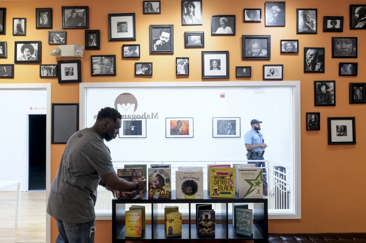 Derrick Young organizes books at Mahogany Books in Washington, DC on April 27, 2018. Young operates the business with his wife, Ramunda. (Photo by Bonnie Jo Mount/The Washington Post via Getty Images)