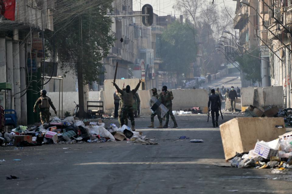 Riot police try to disperse demonstrators during clashes between security forces and anti-government protesters on Rasheed Street in Baghdad, Iraq, Tuesday, Nov. 26, 2019. (AP Photo/Khalid Mohammed)