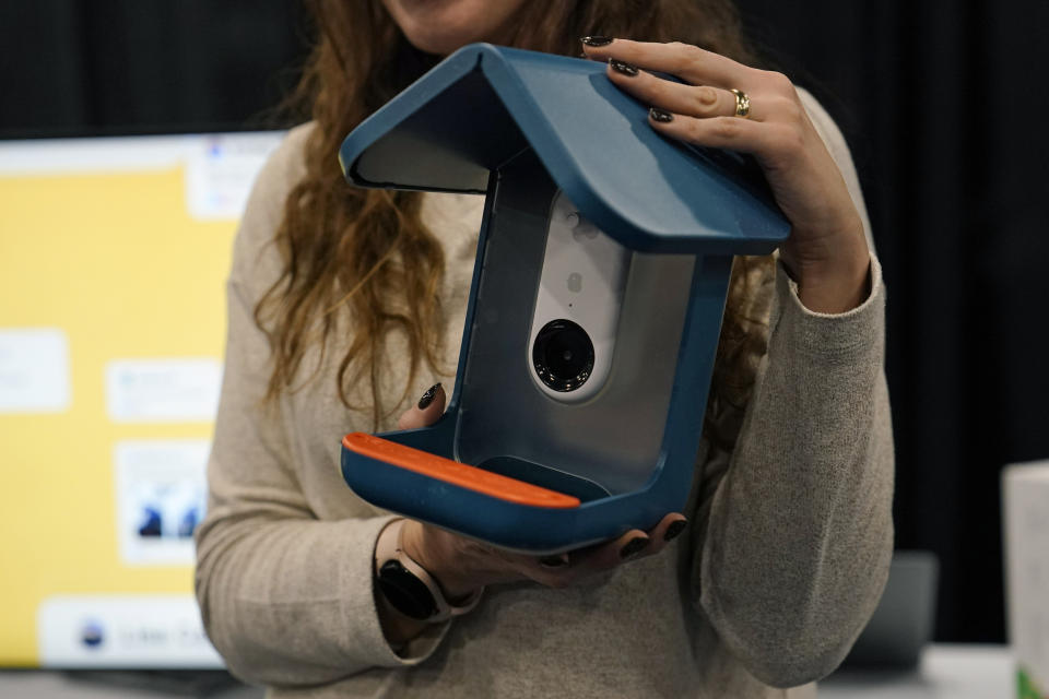 An exhibitor holds up the Bird Buddy smart camera bird feeder during CES Unveiled before the start of the CES tech show, Tuesday, Jan. 3, 2023, in Las Vegas. The AI-powered camera bird feeder notifies you when a bird is feeding, takes pictures and organizes the photos. (AP Photo/John Locher)