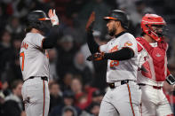 Baltimore Orioles' Anthony Santander, center, is congratulated by Jackson Holliday after his two-run home run off Boston Red Sox pitcher Joely Rodríguez during the eighth inning of a baseball game, Thursday, April 11, 2024, in Boston. At right is Red Sox catcher Reese McGuire. (AP Photo/Charles Krupa)