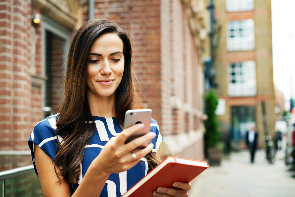 Woman using smart phone on street