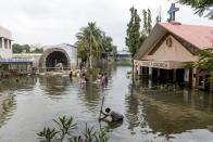 TOPSHOT - Parishioners carry material from the flooded Holy Trinity church following heavy rains in Hyderabad on October 15, 2020. (Photo by NOAH SEELAM / AFP) (Photo by NOAH SEELAM/AFP via Getty Images)