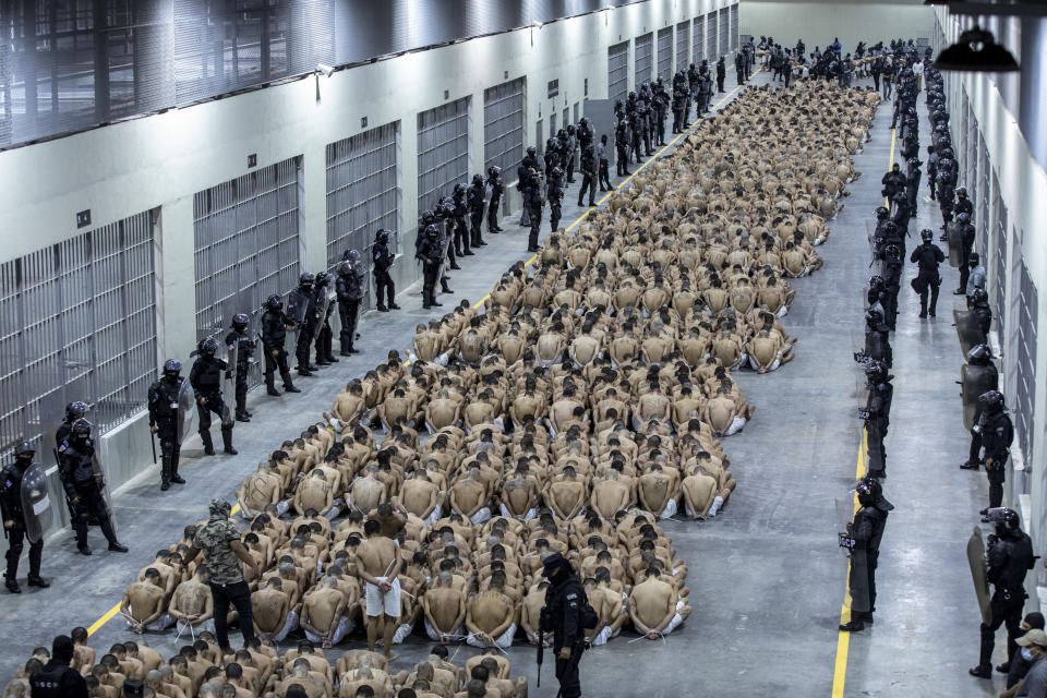 FILE - In this photo provided by El Salvador's presidential press office, inmates identified by authorities as gang members are seated on the prison floor of the Terrorism Confinement Center in Tecoluca, El Salvador, Wednesday, March 15, 2023. Candidates to be Guatemala's next president are taking a cue from Salvadoran President Nayib Bukele of neighboring El Salvador and promising their voters they will build mega-prisons and hammer criminal gangs into submission. (El Salvador presidential press office via AP, File)