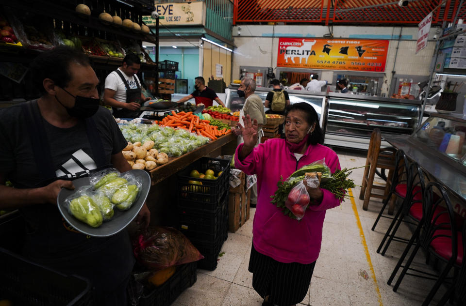 A woman buys vegetables at a market in Mexico City, Tuesday, Aug. 9, 2022. Mexico's annual inflation rate rose to 8.15% in July, driven largely by the rising price of food, according to government data released Tuesday. (AP Photo/Fernando Llano)