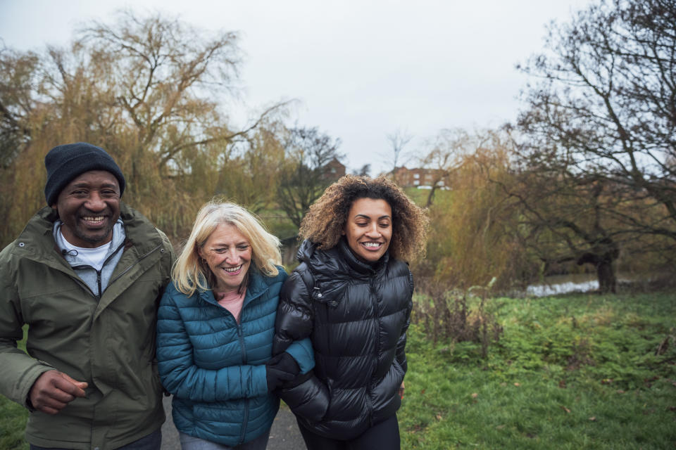 family casual winter clothing and walking through their local park on a morning in December.