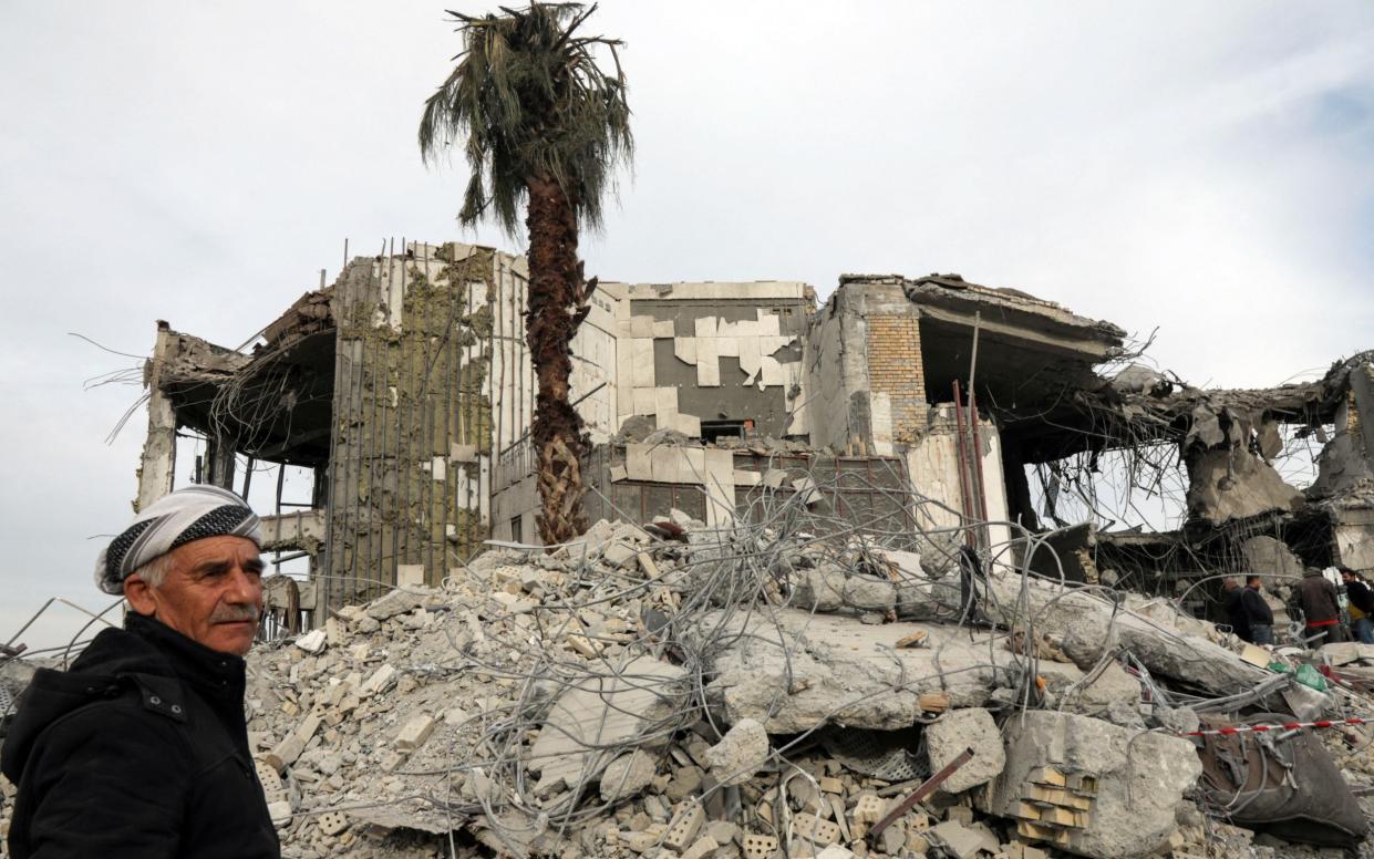 A Kurdish man walks past debris