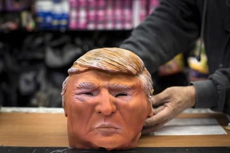Store employee Kenny Lomi displays a Halloween mask of Republican presidential candidate Donald Trump to be photographed at the Village Party Store halloween headquarters in the Manhattan borough of New York, October 15, 2015. REUTERS/Andrew Kelly