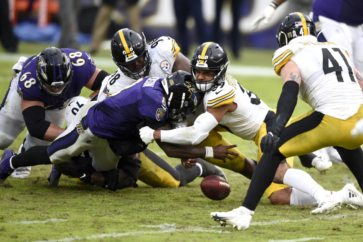 Baltimore Ravens quarterback Lamar Jackson, front left, fumbles the ball while being hit by Pittsburgh Steelers free safety Minkah Fitzpatrick (39) and inside linebacker Vince Williams (98). (AP Photo/Gail Burton)