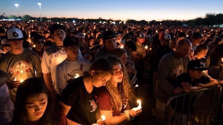 Students and other members of the community attend a candlelit memorial service in February 2018 for the victims of the shooting at Marjory Stoneman Douglas High School in Parkland that killed 17 people. In the wake of the tragedy, legislation was enacted under Gov. Ron DeSantis to provide funding for mental health services in public schools. The Florida-based Moms for Liberty organization has issued a statement against schools offering access to mental health care.