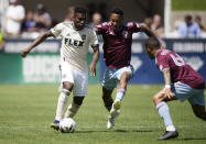 Los Angeles FC midfielder José Cifuentes, left, drives past Colorado Rapids defenders Auston Trusty, center, and Lucas Esteves in the first half of an MLS soccer match Saturday, May 14, 2022, in Commerce City, Colo. (AP Photo/David Zalubowski)