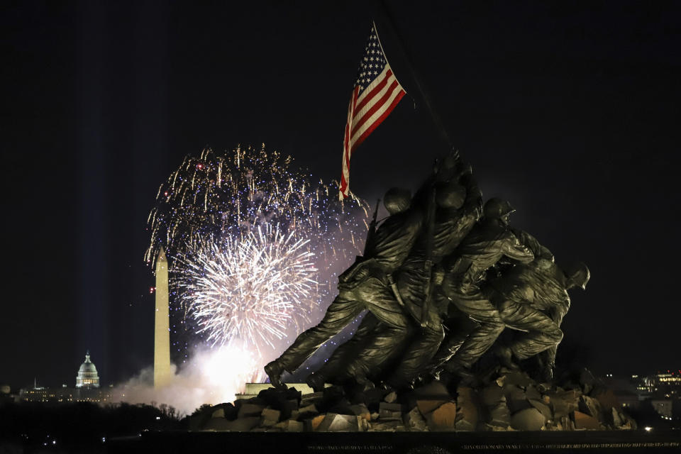 Fireworks explode over the Washington Monument with the Marine Corps War Memorial in the foreground, Wednesday, Jan. 20, 2021, in Arlington, Va., as part of the festivities after President Joe Biden was inaugurated as the 46th president of the United States. (AP Photo/Shafkat Anowar)