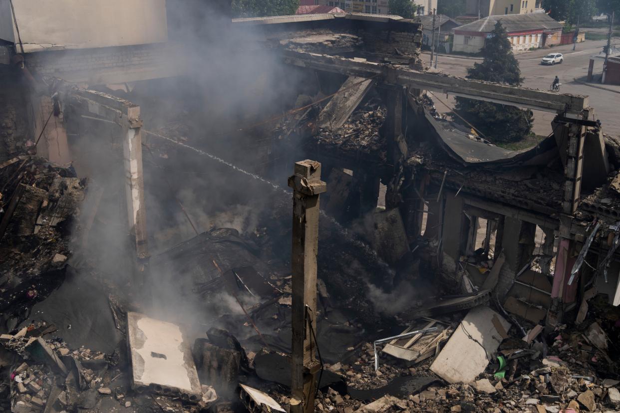 A Ukrainian firefighter works inside a destroyed cultural center in Derhachi, eastern Ukraine, Sunday, May 15, 2022. 