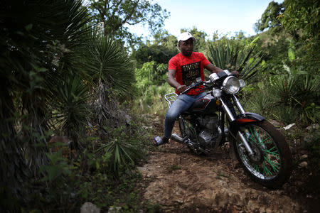 A man rides a motorbike across the trail that connects Boucan Ferdinand with the border between Haiti and Dominican Republic, on the outskirts of Boucan Ferdinand, Haiti, April 8, 2018. REUTERS/Andres Martinez Casares