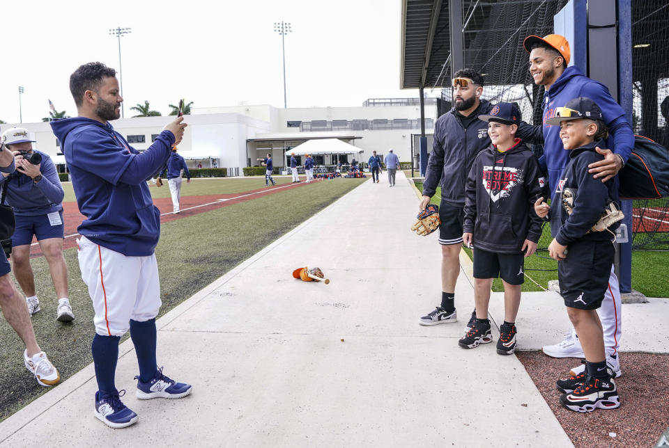 Houston Astros' Jose Altuve, left, takes a photo of takes a photo of Astros' Jeremy Peña and 10-year-olds Bryan Gonzalez, center left, and Domini Torres, right, at baseball spring training n West Palm Beach, Fla., Monday, Feb. 19, 2024. Person being photographed at left is unidentified. (Karen Warren/Houston Chronicle via AP)