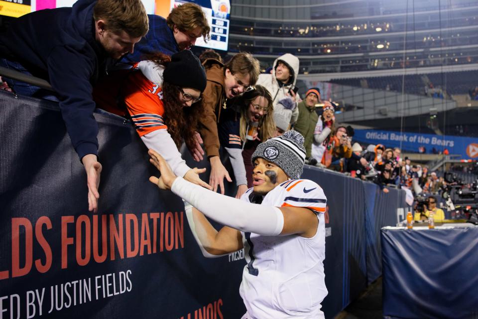 Chicago Bears quarterback Justin Fields (1) greets fans after a game against the Arizona Cardinals at Soldier Field.