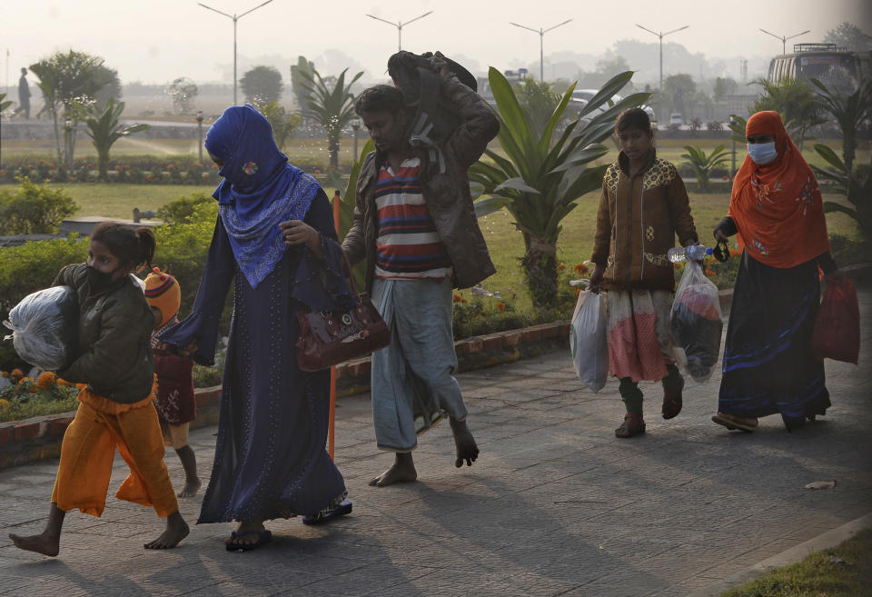 Rohingya refugees walk with their belongings to board a naval vessel to be relocated to to the island of Bhasan Char, in Chattogram, Bangladesh, Saturday, Jan. 30, 2021. Authorities in Bangladesh sent a group of Rohingya refugees to a newly developed island in the Bay of Bengal on Saturday despite calls by human rights groups for a halt to the process. The government insists the relocation plan is meant to offer better living conditions while attempts to repatriate more than 1 million refugees to Myanmar would continue. (AP Photo/Azim Aunon)