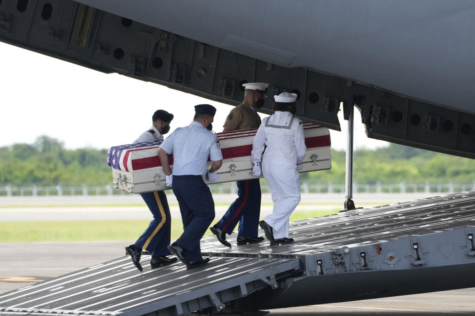 U.S. military carry the possible remains of a WWII U.S. airman found in northern Thailand to a waiting C-17 during a repatriation ceremony Wednesday, May 18, 2022, at the U-Tapao Air Base in Rayong province, eastern Thailand. The possible human remains were found at a crash site in a rice field in northern Thailand by the Defense POW/MIA Accounting Agency and were sent to Hawaii where they will be tested to see if they belong to a U.S. pilot who went missing in 1944. (AP Photo/Sakchai Lalit)