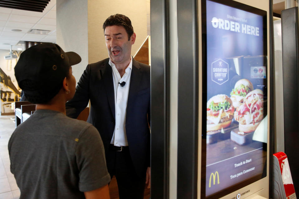 McDonald's CEO Steve Easterbrook speaks with an employee by a self-service ordering kiosk before a press conference in New York November 17, 2016.  REUTERS/Shannon Stapleton