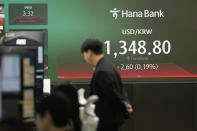 A currency trader watches computer monitors near the screen showing the foreign exchange rate between U.S. dollar and South Korean won at a foreign exchange dealing room in Seoul, South Korea, Friday, March 29, 2024. Asian shares were mostly higher Friday in quiet holiday trading, with markets closed in Hong Kong, Sydney, Singapore and India, among other places. (AP Photo/Lee Jin-man)