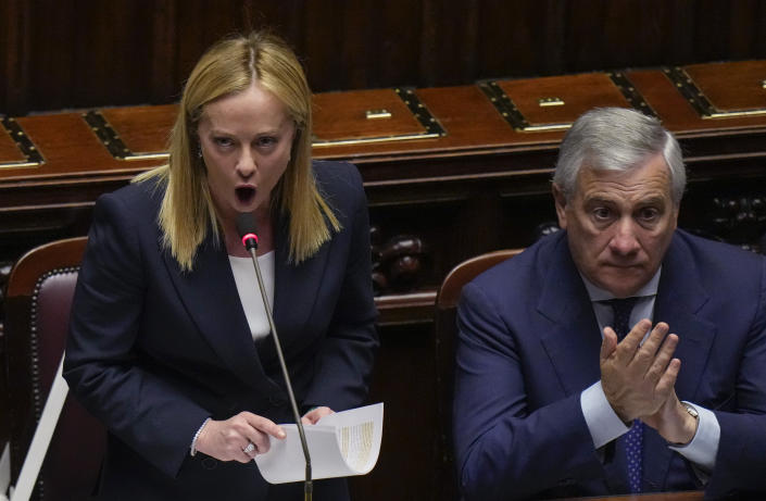 Italian Premier Giorgia Meloni, left, flanked by Foreign Minister Antonio Tajani, addresses the lower Chamber ahead of a confidence vote for her Cabinet, Tuesday, Oct. 25, 2022. Giorgia Meloni, whose party with neo-fascist roots finished first in recent elections, is Italy's first far-right premier since the end of World War II. She is also the first woman to serve as Italian premier. (AP Photo/Alessandra Tarantino)