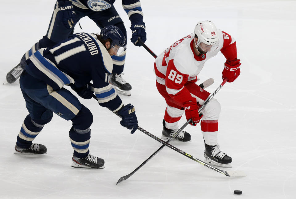 Detroit Red Wings forward Sam Gagner, right, chases the puck in front of Columbus Blue Jackets forward Kevin Stenlund during the second period of an NHL hockey game in Columbus, Ohio, Friday, May 7, 2021. (AP Photo/Paul Vernon)