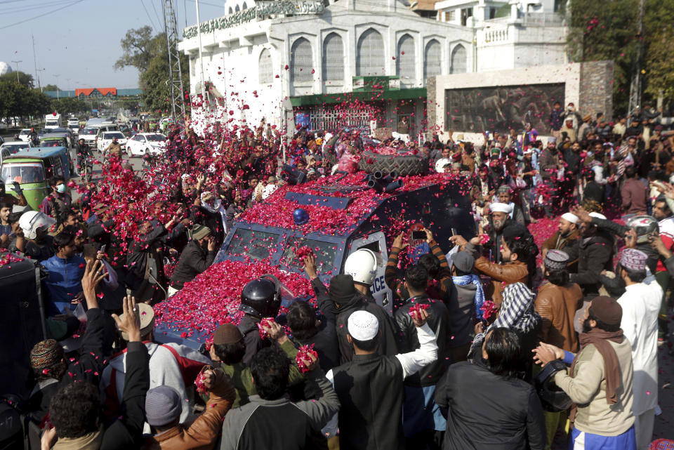 FILE - In this Feb. 8, 2019 file photo, Supporters of Tehreek-e-Labbaik, a Pakistani religious group, shower rose petals on an armored police car carrying their leader, Khadim Hussain Rizvi, as he arrives at a court in Lahore, Pakistan. Terror attacks in Pakistan plummeted by more than 85% over the last decade. It's a welcome statistic for the country, but one that risks being overshadowed by international concern over its efforts to curb terror funding and lingering militant activity that could test any future peace agreement in Afghanistan..(AP Photo/K.M. Chaudary,file)