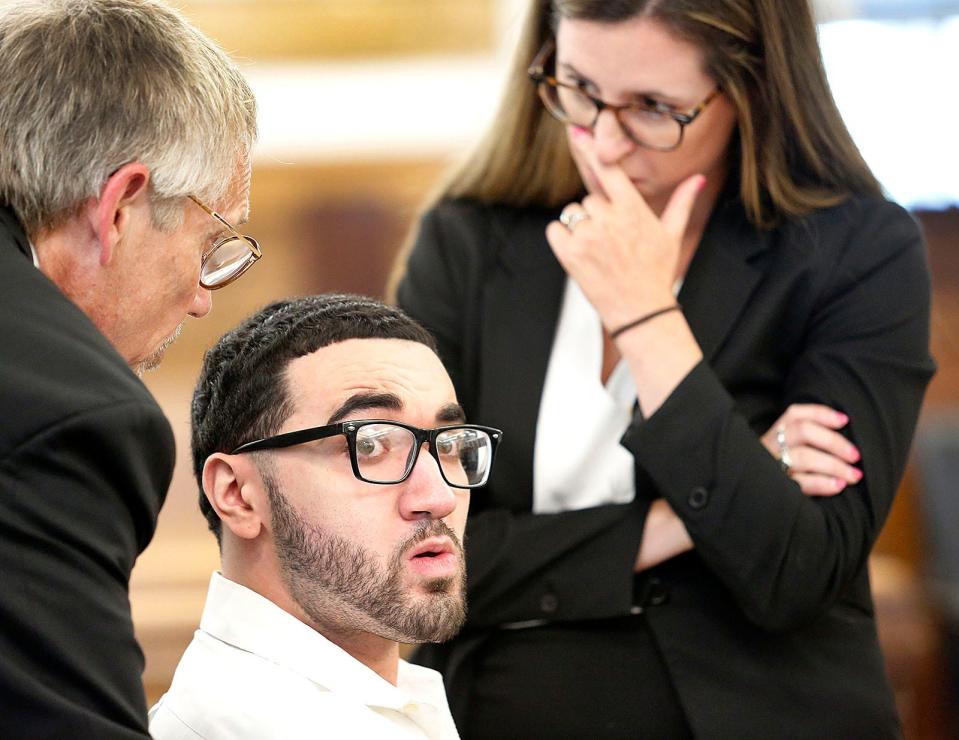 Emanuel Lopes listens to his attorneys Larry Tipton and Christie Feeney at Dedham Superior Court during Lopes' double-murder trial Thursday, July 6, 2023. He is charged with killing Weymouth police Sgt. Michael Chesna and town resident Vera Adams.