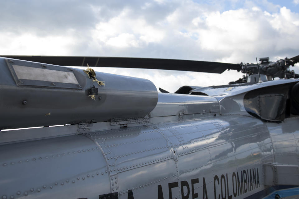 In this photo released by Colombia's Presidency, bullet holes are seen on the fuselage of a Colombian Air Force helicopter that were fired while Colombia's President Ivan Duque and members of his cabinet were traveling on the helicopter, at the airport in Cucuta, Colombia, Friday, June 25, 2021. Duque said the aircraft was attacked while traveling on it with his ministers of defense and interior in the Catatumbo region, on the northeastern border with Venezuela. (Cesar Carrion/Presidency of Colombia via AP)