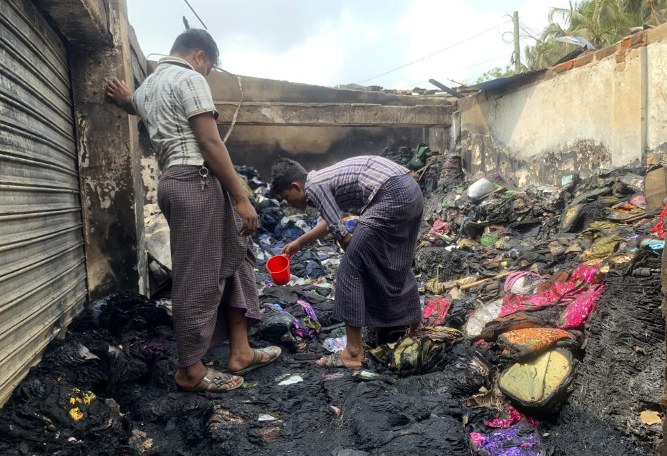 People inspect the debris after a fire in a makeshift market near a Rohingya refugee camp in Kutupalong, Bangladesh, Friday, April 2, 2021. The fire broke out early Friday when residents of the sprawling Kutupalong camp for Myanmar's Rohingya refugees were asleep. (AP Photo/Shafiqur Rahman)