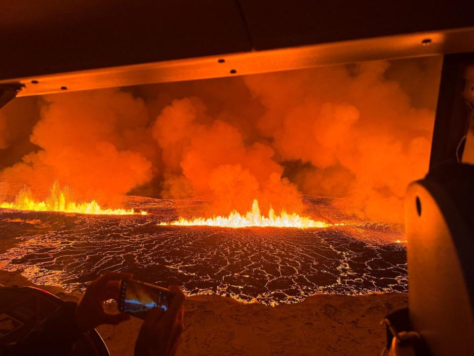 Emergency personnel and scientists observe the billowing smoke and flowing lava (AFP via Getty Images)