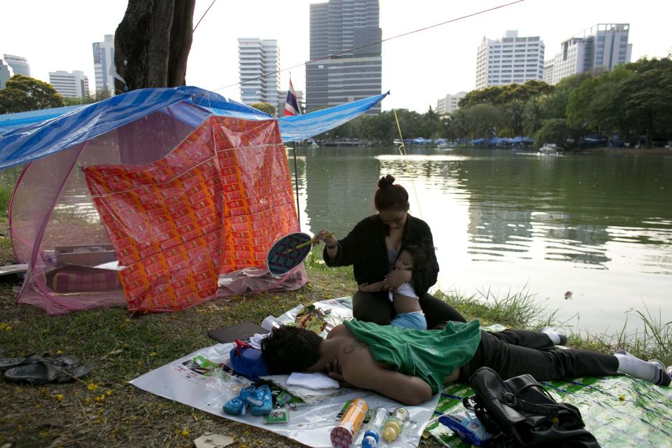 Anti-government protesters relax in the afternoon heat in Lumpini Park in downtown Bangkok April 6, 2014. Viewed from above, with it's sea of blue tarpaulin sheets, Bangkok's Lumpini Park looks like a shelter for victims of a natural disaster. Surrounded by skyscrapers and once a haven for joggers, the Thai capital's most famous park has become the temporary home of more than 10,000 supporters of a movement that's been trying for five months to bring down Prime Minister Yingluck Shinawatra. Picture taken April 6, 2014. REUTERS/Darren Whiteside (THAILAND - Tags: POLITICS CIVIL UNREST)