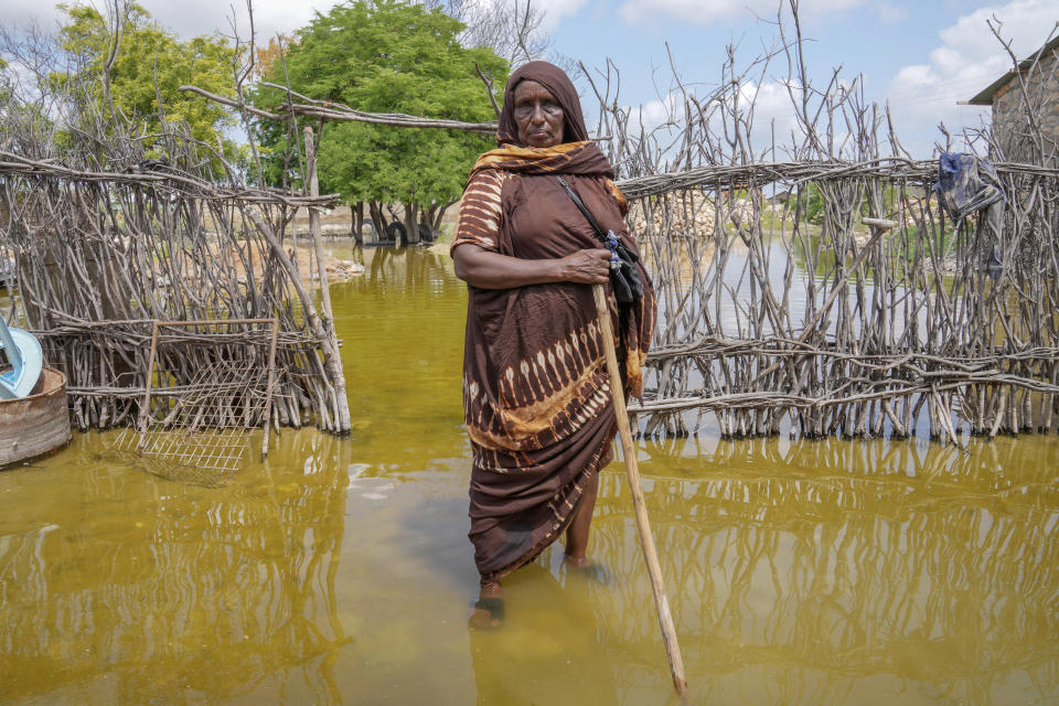 Abdia Sheikh Abdullahi, 70-years-old, stands in the water by her flooded house in Mandera County, Kenya, Wednesday, Dec. 13, 2023. Rains began pounding the country in October. At the end of November Kenya President William Ruto convened an emergency cabinet meeting saying 38 of Kenya’s 47 counties had been affected by floods and mudslides made worse by the El Niño phenomenon. (AP Photo/Brian Inganga)