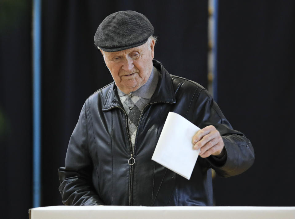 A man casts his vote in Bucharest, Romania, Sunday, Nov. 10, 2019. Voting got underway in Romania's presidential election after a lackluster campaign overshadowed by a political crisis which saw a minority government installed just a few days ago. (AP Photo/Vadim Ghirda)